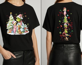 May include: A black t-shirt featuring a front graphic of a green character in a Santa hat, a child, and a dog near a Christmas tree. The back graphic shows a vertical stack of the child, the tree, the green character, and the dog with ornaments.