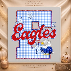 May include: A DTF transfer design featuring a large letter E with a light blue and white gingham pattern, outlined in red glitter. The word Eagles is written in red script with a blue glitter outline. A bald eagle graphic sits near the letter.