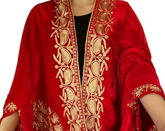 May include: A red velvet shawl with gold embroidery. The shawl has a paisley design and is trimmed with a gold border.