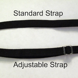 May include: Two black straps are displayed against a white background. The top strap is labeled "Standard Strap." The bottom strap is labeled "Adjustable Strap" and features clear plastic hardware for adjustment. The straps are likely for clothing or accessories.