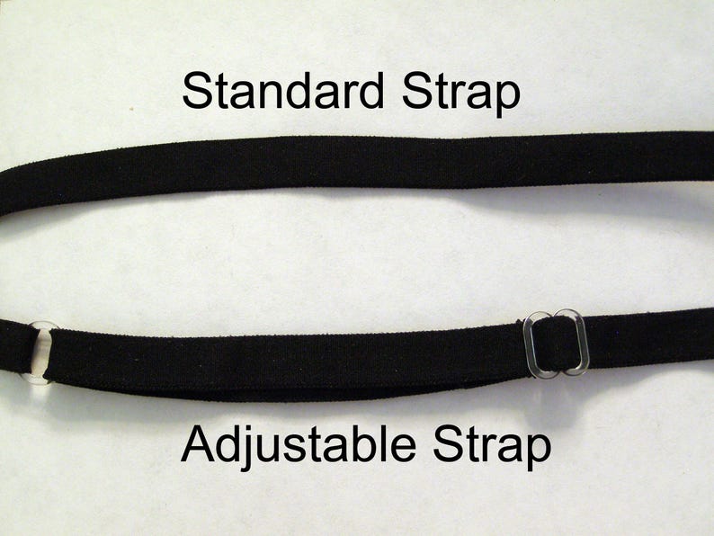 May include: Two black straps are displayed against a white background. The top strap is labeled "Standard Strap." The bottom strap is labeled "Adjustable Strap" and features clear plastic hardware for adjustment. The straps are likely for clothing or accessories.