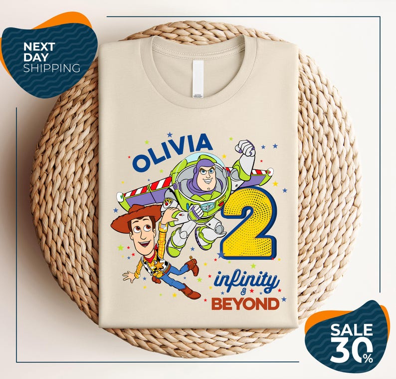 A t-shirt featuring a character from the Toy Story franchise, specifically Buzz Lightyear, along with the text "Olivia 2 Infinity Beyond". The t-shirt is displayed on a woven basket, and there are two sale signs indicating a 30% discount.