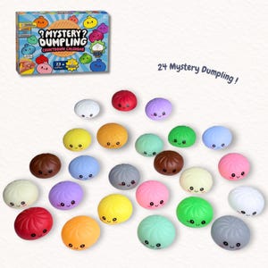 May include: A Mystery Dumpling Countdown Calendar box set featuring 24 small, colorful, round dumpling-shaped toys. Each toy has a smooth surface, a pleated top, and a printed face with two eyes and a smiling mouth. The colors include red, yellow, green, blue, purple, pink, white, gray, and brown.