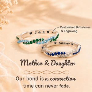 May include: Two silver rings featuring twisted bands set with colourful gemstones. One ring has green and light blue stones with the engraving J & E. The other ring has blue and clear stones with the engraving forever. Text reads Mother & Daughter.