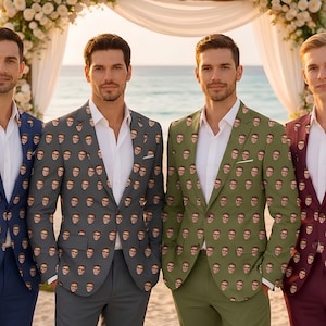 May include: Four men in patterned blazers and white shirts pose on a beach. The blazers are navy, grey, olive green, and burgundy, each with a repeating face design. The background features a floral arch and the sea.