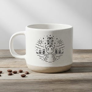 Peut inclure: Une tasse &agrave; caf&eacute; en c&eacute;ramique blanche avec une base beige. La tasse pr&eacute;sente une illustration en noir et blanc d'un personnage sur un chemin avec des fleurs, des &eacute;toiles et un objet en forme d'&eacute;toile. Des grains de caf&eacute; sont &eacute;parpill&eacute;s sur la surface en bois.