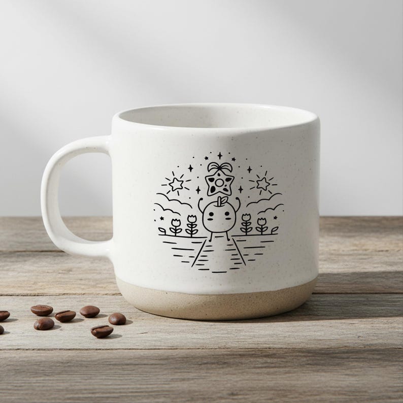 Peut inclure: Une tasse &agrave; caf&eacute; en c&eacute;ramique blanche avec une base beige. La tasse pr&eacute;sente une illustration en noir et blanc d'un personnage sur un chemin avec des fleurs, des &eacute;toiles et un objet en forme d'&eacute;toile. Des grains de caf&eacute; sont &eacute;parpill&eacute;s sur la surface en bois.