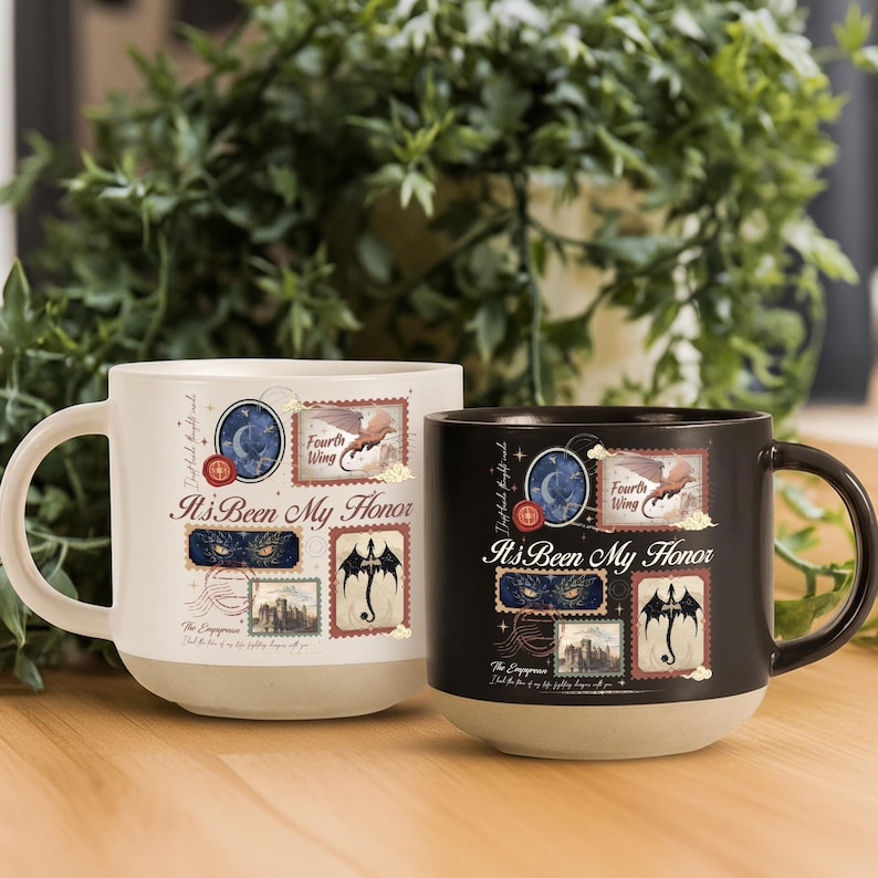 May include: Two ceramic mugs, one white and one black, featuring the text "It's Been My Honor" and "Fourth Wing" alongside illustrations of dragons, a castle, and celestial motifs arranged in a stamp-like collage design with a light base.