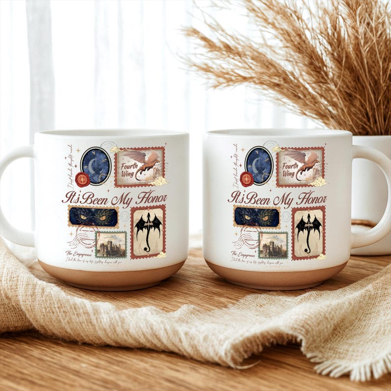 May include: Two white ceramic mugs with a tan base, each featuring a collage of postage stamp-style illustrations including a dragon, a castle, and eyes. The text reads "It's Been My Honor," "Fourth Wing," and "The Empyrean" in a script font.