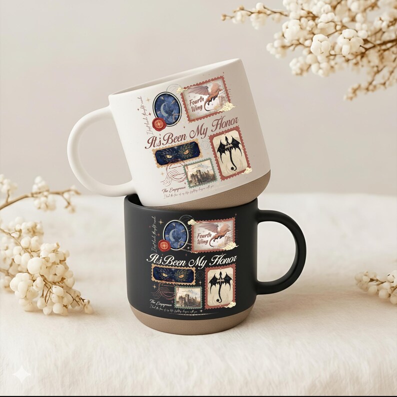 May include: Two ceramic mugs, one white and one black, each featuring a tan base and a graphic design of postage-style stamps. The design includes the text "It's Been My Honor," "Fourth Wing," and "The Empyrean," alongside illustrations of a dragon, eyes, and a moon.