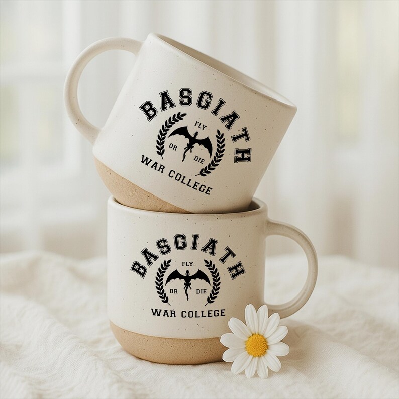 May include: Two stacked ceramic mugs with a speckled cream finish and a tan base. The mugs feature a black graphic with the text Basgiath War College, a dragon silhouette, and the words Fly or Die surrounded by a laurel wreath design.