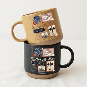May include: Two ceramic mugs, one tan and one black, each featuring a graphic design with the text "It's Been My Honor," "Fourth Wing," and "The Empyrean." The design includes illustrations of a dragon, a castle, and eyes, with a speckled finish.