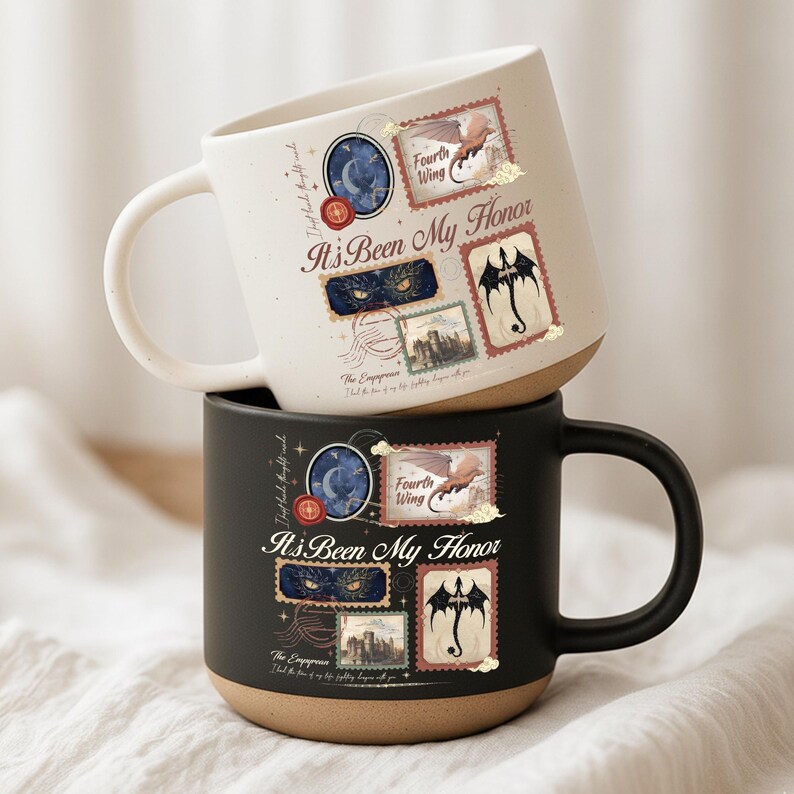 May include: Two ceramic mugs, one cream and one black, featuring a graphic design with the text "It's Been My Honor," "Fourth Wing," and "The Empyrean." The design includes postage stamp-style illustrations of a dragon, eyes, and a castle.