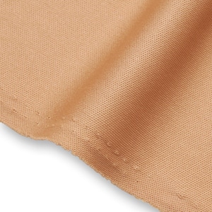 Op de afbeelding: Een stuk lichtbruine stof met een fijne, uniforme mesh-textuur. Het materiaal heeft een consistent weefpatroon over het gehele oppervlak en vertoont een soepele val met zachte plooien die licht en schaduw op het textiel creëren.