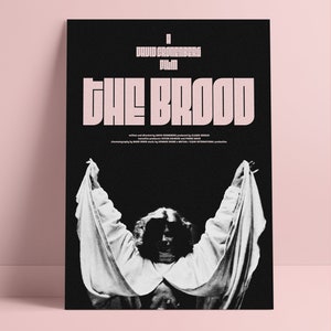 Könnte beinhalten: Schwarz-weiß Filmplakat für "The Brood" von David Cronenberg. Der Titel ist in großen, stilisierten, rosa Buchstaben gehalten. Das Bild zeigt eine Person in weißem Gewand mit erhobenen Armen. Zusätzlicher Text mit Credits.