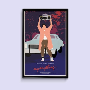 Op de afbeelding: Een vintage-stijl filmposter voor de film "Say Anything..." met een man die een draagbare cassettedeck boven zijn hoofd houdt voor een auto. De poster is in een zwart frame.