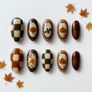 May include: A set of ten oval-shaped press-on nails featuring autumn-themed designs including black and cream checkered patterns, brown and cream checkered patterns, orange pumpkins, a black bat, and brown argyle prints, accented by small maple leaves.