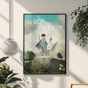 May include: Framed poster featuring the anime film "The Boy and the Heron." The artwork depicts a boy with a staff, a heron, and a dark figure on a rock, with a castle in the background. The title is displayed at the top.