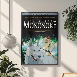 Puede incluir: P&oacute;ster enmarcado de la pel&iacute;cula "La Princesa Mononoke" de Studio Ghibli. La imagen muestra un lobo blanco con un jinete, sobre un fondo de bosque. El t&iacute;tulo y el nombre del director son visibles.