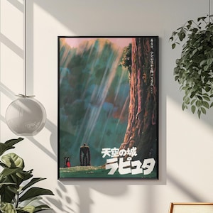 May include: A framed poster with Japanese text and imagery from the animated film "Castle in the Sky." The artwork shows a large figure and two smaller characters in a forest, with light beams shining through the trees. The poster is in a black frame.
