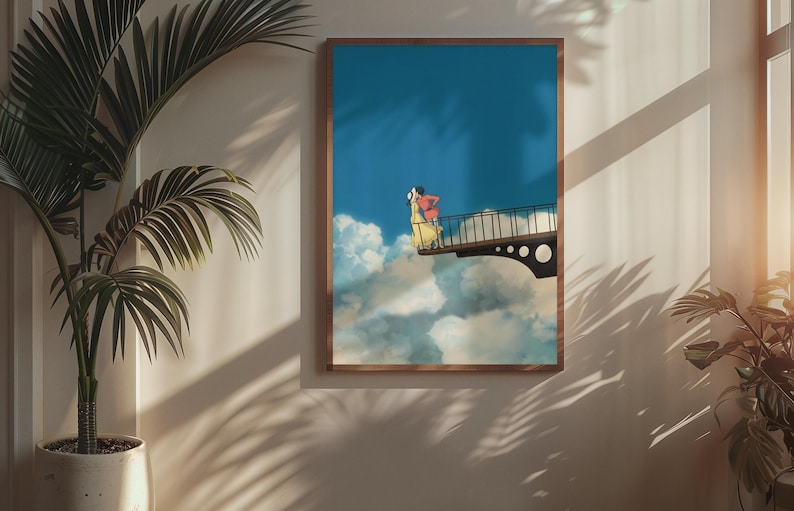May include: A framed art print depicts a surreal scene of two figures on a bridge above clouds against a blue sky. The artwork features a brown frame and is displayed on a neutral-colored wall, with a potted plant in the foreground.