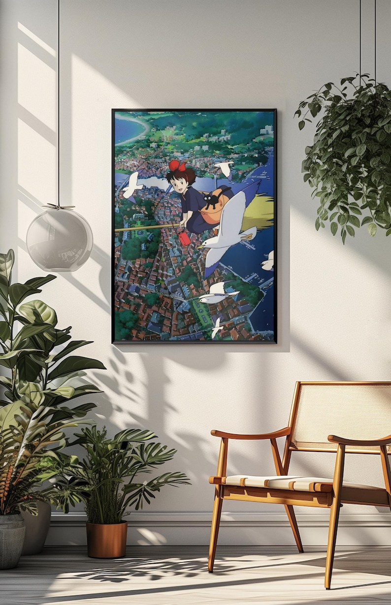 May include: Framed art print featuring a vibrant anime scene. A young girl with a red bow flies on a broomstick with a black cat, seagulls, and a cityscape below. The artwork is set against a blue sky and framed in black.