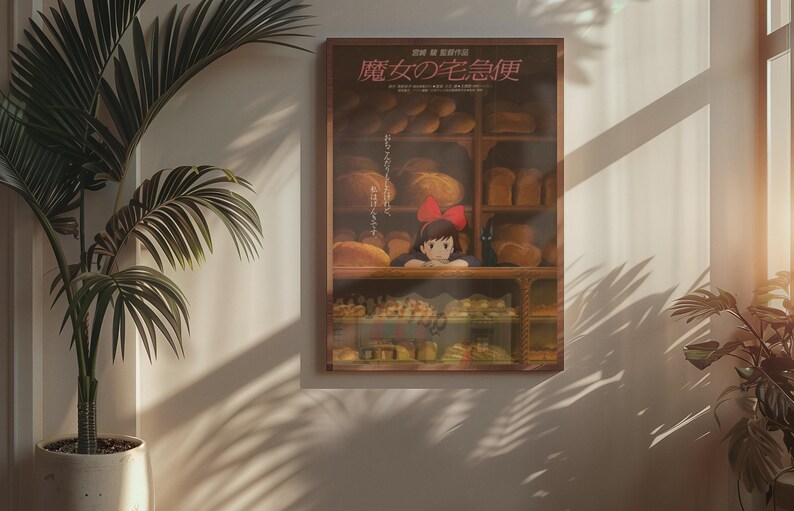 May include: A framed poster featuring a scene from an animated film, depicting a young girl with a red bow in a bakery. The poster has Japanese text and is surrounded by a wooden frame. The scene includes various baked goods.