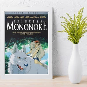 Puede incluir: P&oacute;ster enmarcado de la pel&iacute;cula de animaci&oacute;n "La Princesa Mononoke" con un lobo blanco y un jinete. El p&oacute;ster tiene un fondo negro con el t&iacute;tulo de la pel&iacute;cula en letras blancas grandes y el nombre del director.