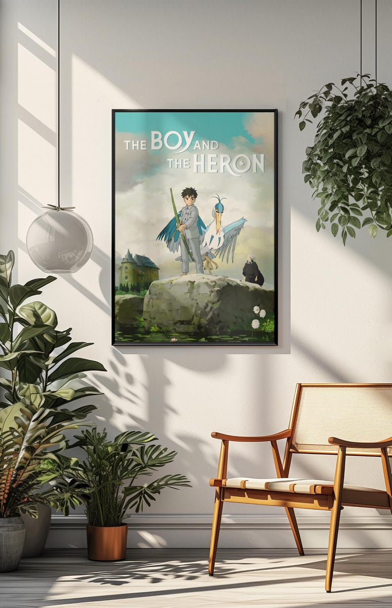 May include: Framed poster featuring the anime film "The Boy and the Heron." The artwork depicts a boy with a staff, a heron, and a dark figure on a rock, with a castle in the background. The title is displayed at the top.