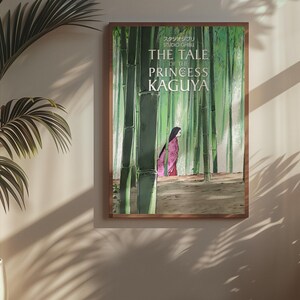 May include: A framed poster featuring the animated film "The Tale of the Princess Kaguya." The artwork depicts a woman in a pink kimono walking through a bamboo forest. The poster is in a wooden frame and hangs on a beige wall.