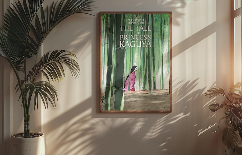 May include: A framed poster featuring the animated film "The Tale of the Princess Kaguya." The artwork depicts a woman in a pink kimono walking through a bamboo forest. The poster is in a wooden frame and hangs on a beige wall.
