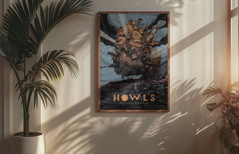 May include: Framed poster featuring a detailed illustration of Howl's Moving Castle, a fantastical structure with intricate details, set against a cloudy sky. The poster has a brown frame and the title "Howl's Moving Castle" is displayed in gold lettering.