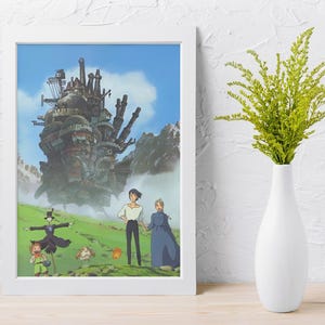 May include: Framed print of an animated movie scene featuring a large, complex structure with smokestacks against a blue sky. Characters stand in a green field. A white vase holds green plants.