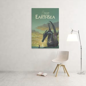 May include: A framed poster of "Tales from Earthsea" featuring a dragon and a person. The poster is mounted on a white wall. A white chair, a book, and a lamp are in the foreground.