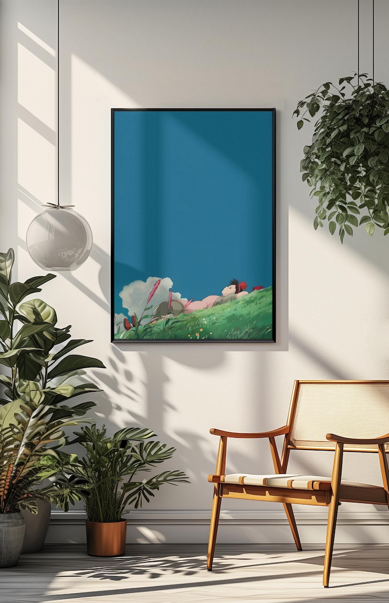 K&ouml;nnte beinhalten: Gerahmter Kunstdruck mit einer ruhigen Anime-Szene. Eine Person liegt auf einem gr&uuml;nen H&uuml;gel unter blauem Himmel mit Wolken. Das Kunstwerk befindet sich in einem schwarzen Rahmen, der an einer wei&szlig;en Wand ausgestellt ist, mit einem Holzstuhl und Pflanzen in der N&auml;he.