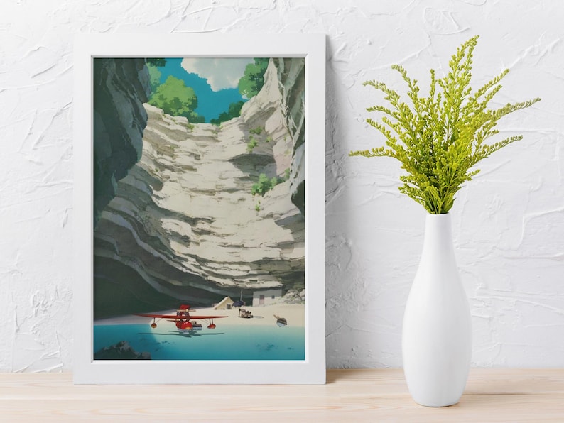 Puede incluir: Una impresi&oacute;n art&iacute;stica enmarcada representa un paisaje con un hidroavi&oacute;n rojo sobre una extensi&oacute;n de agua azul, rodeado de formaciones rocosas en capas. El cielo es visible en la parte superior, con nubes y &aacute;rboles verdes. Un jarr&oacute;n blanco contiene plantas verdes.