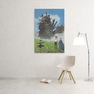 May include: A framed art print featuring a scene from the animated film "Howl's Moving Castle." The artwork depicts a large, moving castle, characters, and a green landscape under a blue sky. The print is displayed on a white wall.