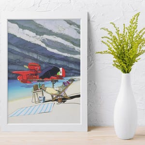 Peut inclure: Impression d'art encadr&eacute;e repr&eacute;sentant un hydravion rouge, une personne se relaxant dans une chaise longue sous un parasol et une serviette de plage ray&eacute;e. L'arri&egrave;re-plan montre une falaise rocheuse et de l'eau bleue. Un vase blanc avec des plantes vertes est &agrave; droite.