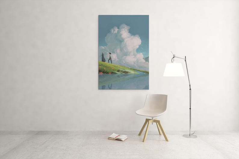 May include: A vertical art print depicts a serene landscape with a person walking on a grassy hill near a body of water. A large cloud formation dominates the sky. A modern chair, lamp, and open book are in the foreground.