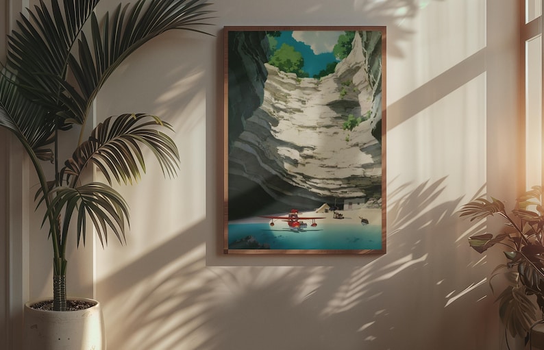 Puede incluir: Una impresi&oacute;n enmarcada representa un hidroavi&oacute;n rojo sobre una extensi&oacute;n de agua turquesa, con un tel&oacute;n de fondo de una formaci&oacute;n rocosa en capas. La obra de arte est&aacute; en un marco de madera y la escena est&aacute; iluminada por la luz del sol.