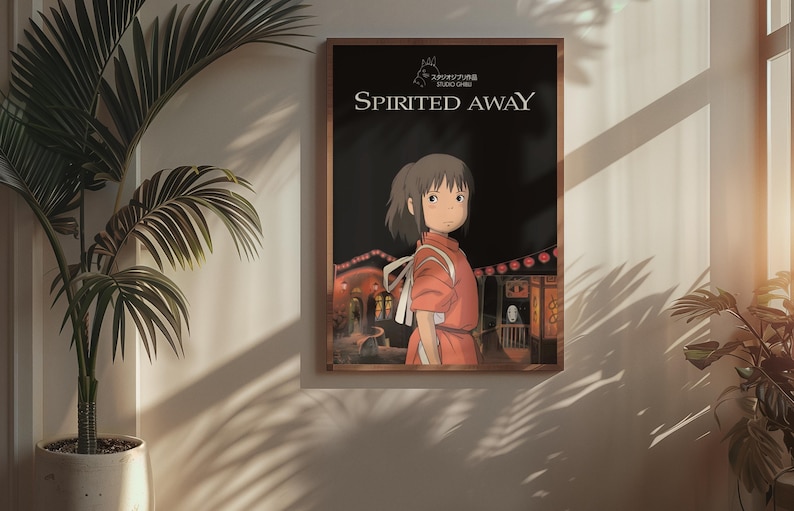 Puede incluir: Un p&oacute;ster enmarcado de la pel&iacute;cula de animaci&oacute;n "El viaje de Chihiro". La obra de arte representa a una joven con un atuendo rojo, frente a una escena nocturna con linternas y edificios. El t&iacute;tulo se muestra en texto blanco.