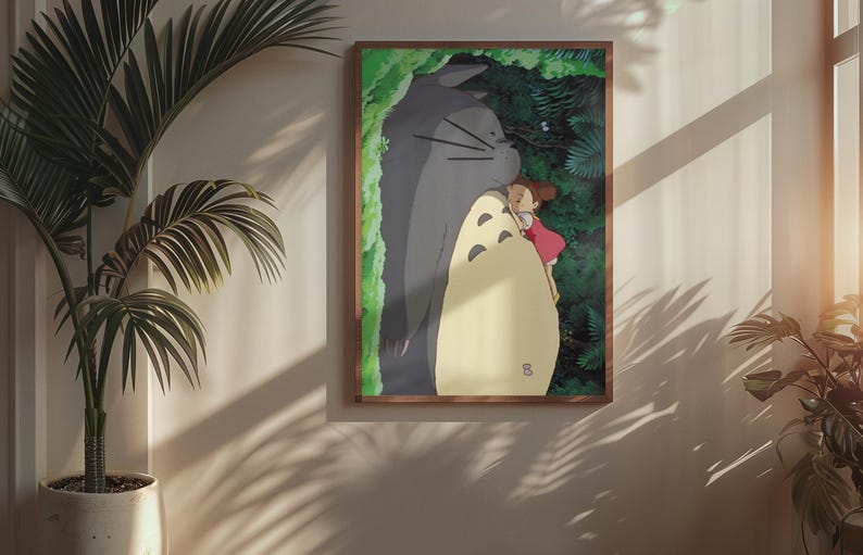 Pu&ograve; includere: Una stampa artistica incorniciata raffigurante una scena del film d'animazione Il mio vicino Totoro. L'opera mostra un grande Totoro grigio che abbraccia una bambina con un vestito rosso, sullo sfondo di una foresta verde.
