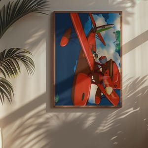 May include: A framed art print featuring a vibrant illustration of a red seaplane soaring through a blue sky with clouds. The artwork is displayed on a wall, with a potted plant in the foreground, and a window casting shadows.
