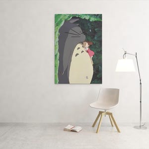 Pu&ograve; includere: Una stampa artistica incorniciata con una scena del film d'animazione, Il mio vicino Totoro. L'opera raffigura Totoro, un grande spirito della foresta grigio, con una bambina in un vestito rosa. Lo sfondo mostra un fogliame verde.