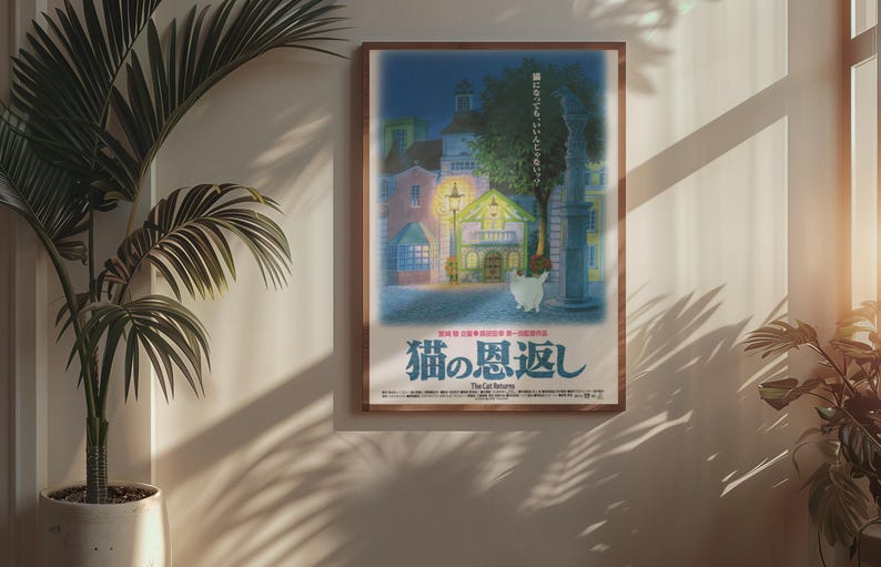 Puede incluir: Un p&oacute;ster enmarcado con una ilustraci&oacute;n nocturna de edificios, un gato y texto japon&eacute;s. El p&oacute;ster tiene un marco marr&oacute;n y cuelga de una pared beige. Una planta en maceta est&aacute; en primer plano.