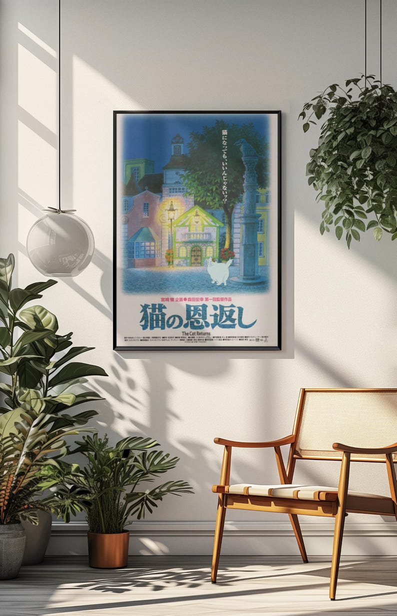 Puede incluir: Un p&oacute;ster enmarcado de la pel&iacute;cula de anime "Haru en el reino de los gatos". El p&oacute;ster muestra un paisaje urbano nocturno con un gato blanco y texto japon&eacute;s. El p&oacute;ster est&aacute; en una pared blanca, con una silla de madera y plantas.