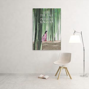 May include: A framed poster of "The Tale of the Princess Kaguya" hangs on a white wall. The artwork depicts a woman in a pink kimono walking through a bamboo forest. A white chair, a book, and a lamp are in the room.