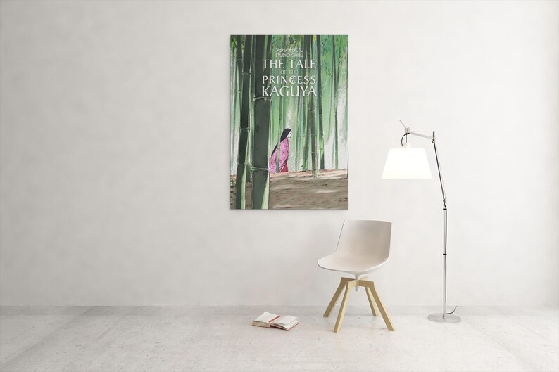 May include: A framed poster of "The Tale of the Princess Kaguya" hangs on a white wall. The artwork depicts a woman in a pink kimono walking through a bamboo forest. A white chair, a book, and a lamp are in the room.