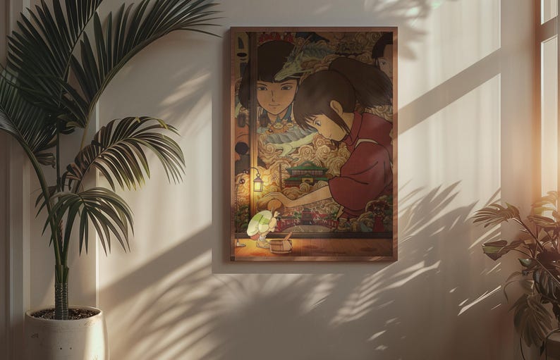 May include: A framed art print depicting a scene from an animated film. The artwork shows a young girl in a red garment, with a detailed background of a fantastical setting. The print is mounted on a wooden frame and displayed on a wall.