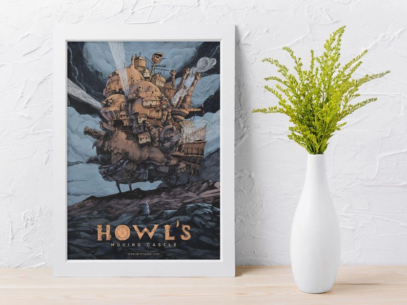 May include: A framed print of Howl's Moving Castle. The artwork depicts a detailed, steampunk-style castle floating in the sky, with a blue and gray background. The title "HOWL'S MOVING CASTLE" is displayed in gold lettering at the bottom of the print.